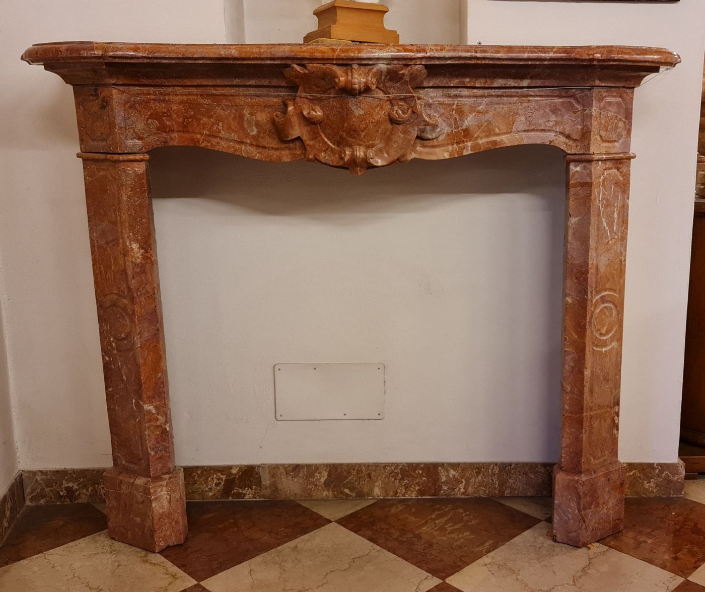 Chimenea antigua con escudo en mármol breccia